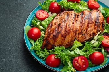 Kızarmış tavuk göğsü (fileto) lahana salatası ve kiraz domatesli. Kırsal arkaplanda üst görünüm