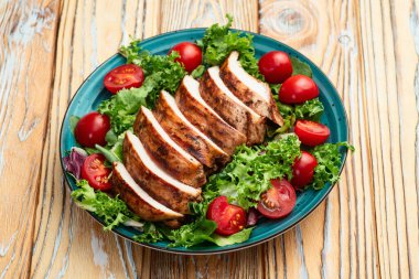 Kızarmış tavuk göğsü (fileto) lahana salatası ve kiraz domatesli. Kırsal arkaplanda üst görünüm