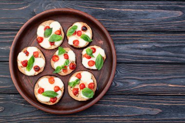 İtalyan mini pizzası. Patlıcan peynirli ve fesleğenli. Kırsal arkaplan üstü görünümünde