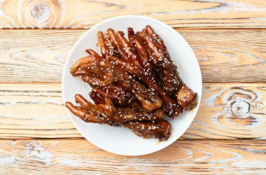 Caramelized korean or Chinese chicken foots ( paws ) with sesame . Top view photography clipart