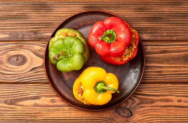 Pirinç, havuç ve etle doldurulmuş biber (paprika). Kırsal arkaplan fotoğrafçılığının üst görünümü