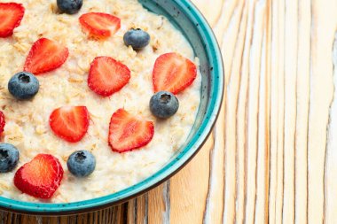 Ev yapımı kahvaltı. Sütlü ve dutlu yulaf ezmesi. Kırsal arkaplanda üst görünüm