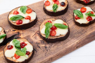 İtalyan mini pizzası. Patlıcan peynirli ve fesleğenli. Kırsal arkaplan üstü görünümünde