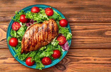 Kızarmış tavuk göğsü (fileto) lahana salatası ve kiraz domatesli. Kırsal arkaplanda üst görünüm