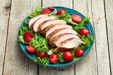 Kızarmış tavuk göğsü (fileto) lahana salatası ve kiraz domatesli. Kırsal arkaplanda üst görünüm
