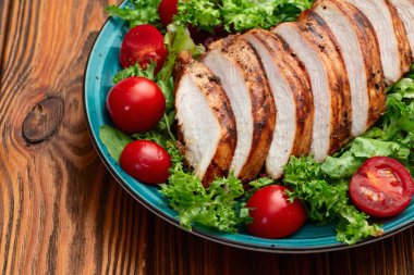 Kızarmış tavuk göğsü (fileto) lahana salatası ve kiraz domatesli. Kırsal arkaplanda üst görünüm