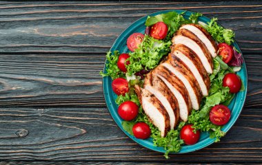 Kızarmış tavuk göğsü (fileto) lahana salatası ve kiraz domatesli. Kırsal arkaplanda üst görünüm