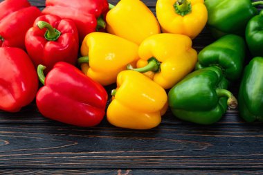 Taze tatlı dolmalık biber (kırmızı biber) fotoğraf kırmızı, yeşil ve sarı. Renkli sebze. Kırsal arkaplanda üst görünüm