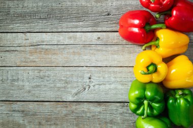 Taze tatlı dolmalık biber (kırmızı biber) fotoğraf kırmızı, yeşil ve sarı. Renkli sebze. Kırsal arkaplanda üst görünüm