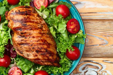 Kızarmış tavuk göğsü (fileto) lahana salatası ve kiraz domatesli. Kırsal arkaplanda üst görünüm