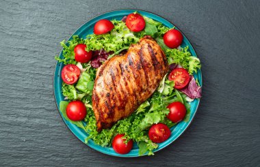 Kızarmış tavuk göğsü (fileto) lahana salatası ve kiraz domatesli. Kırsal arkaplanda üst görünüm