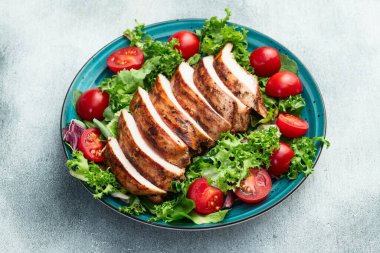 Kızarmış tavuk göğsü (fileto) lahana salatası ve kiraz domatesli. Kırsal arkaplanda üst görünüm