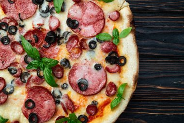 Mozzarella peynirli pizza, salam sosisi, zeytin ve fesleğen. Üst manzara peperonisi