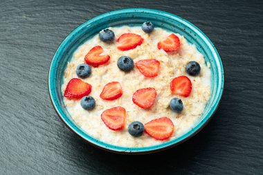 Ev yapımı kahvaltı. Sütlü ve dutlu yulaf ezmesi. Kırsal arkaplanda üst görünüm