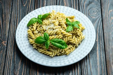 Fesleğen soslu makarna. İtalyan yemek fotoğrafçılığı. Kırsal arkaplanda üst görünüm