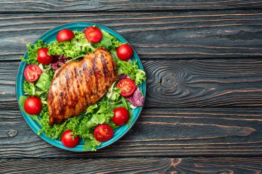 Kızarmış tavuk göğsü (fileto) lahana salatası ve kiraz domatesli. Kırsal arkaplanda üst görünüm