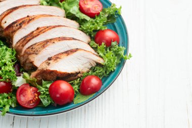 Kızarmış tavuk göğsü (fileto) lahana salatası ve kiraz domatesli. Kırsal arkaplanda üst görünüm