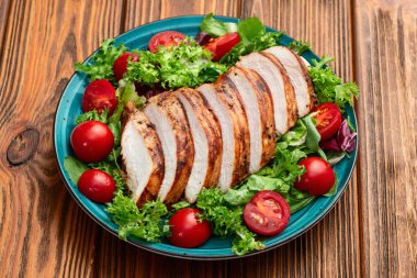 Kızarmış tavuk göğsü (fileto) lahana salatası ve kiraz domatesli. Kırsal arkaplanda üst görünüm