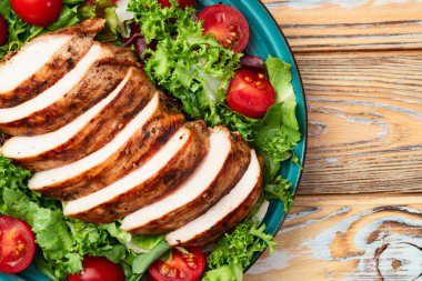 Kızarmış tavuk göğsü (fileto) lahana salatası ve kiraz domatesli. Kırsal arkaplanda üst görünüm