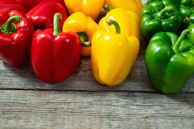 Taze tatlı dolmalık biber (kırmızı biber) fotoğraf kırmızı, yeşil ve sarı. Renkli sebze. Kırsal arkaplanda üst görünüm