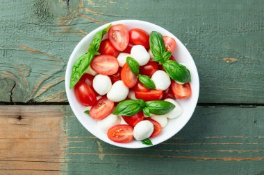 Fesleğen yaprakları, kiraz domatesleri ve mozzarella peyniri. Kase yemek fotoğrafçılığında. Üst görünüm