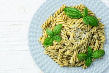 Fesleğen soslu makarna. İtalyan yemek fotoğrafçılığı. Kırsal arkaplanda üst görünüm
