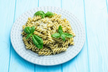 Fesleğen soslu makarna. İtalyan yemek fotoğrafçılığı. Kırsal arkaplanda üst görünüm