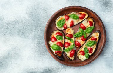 İtalyan mini pizzası. Patlıcan peynirli ve fesleğenli. Kırsal arkaplan üstü görünümünde