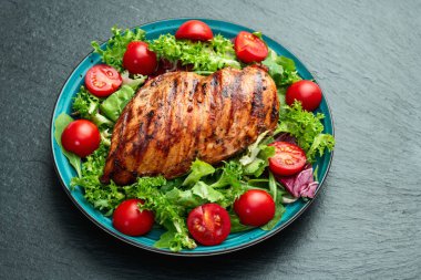 Kızarmış tavuk göğsü (fileto) lahana salatası ve kiraz domatesli. Kırsal arkaplanda üst görünüm