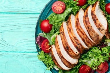 Kızarmış tavuk göğsü (fileto) lahana salatası ve kiraz domatesli. Kırsal arkaplanda üst görünüm