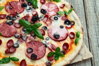 Mozzarella peynirli pizza, salam sosisi, zeytin ve fesleğen. Üst manzara peperonisi