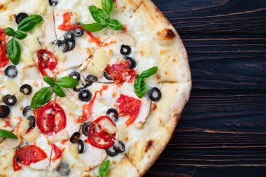 Mozzarella peynirli pizza, zeytin, tavuk, ananas, fesleğen ve domates. Üst görünüm