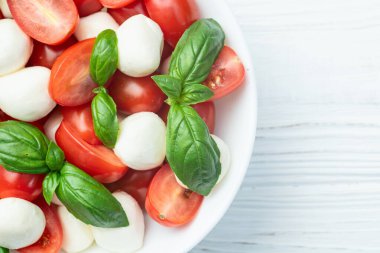 Fesleğen yaprakları, kiraz domatesleri ve mozzarella peyniri. Kase yemek fotoğrafçılığında. Üst görünüm