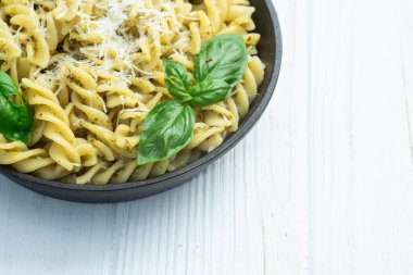 Fesleğen soslu makarna. İtalyan yemek fotoğrafçılığı. Kırsal arkaplanda üst görünüm