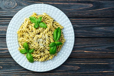 Fesleğen soslu makarna. İtalyan yemek fotoğrafçılığı. Kırsal arkaplanda üst görünüm