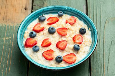Ev yapımı kahvaltı. Sütlü ve dutlu yulaf ezmesi. Kırsal arkaplanda üst görünüm