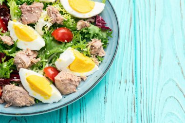 Yumurta ve domates fotoğraflı konserve ton balığı salatası. Kırsal arkaplanda üst görünüm