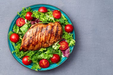 Kızarmış tavuk göğsü (fileto) lahana salatası ve kiraz domatesli. Kırsal arkaplanda üst görünüm