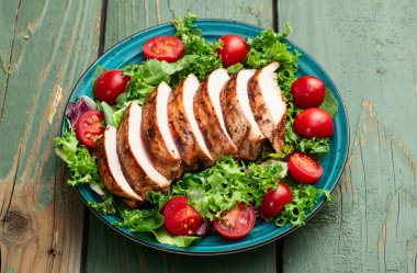 Kızarmış tavuk göğsü (fileto) lahana salatası ve kiraz domatesli. Kırsal arkaplanda üst görünüm