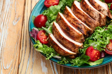 Kızarmış tavuk göğsü (fileto) lahana salatası ve kiraz domatesli. Kırsal arkaplanda üst görünüm