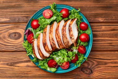 Kızarmış tavuk göğsü (fileto) lahana salatası ve kiraz domatesli. Kırsal arkaplanda üst görünüm