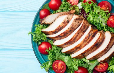 Kızarmış tavuk göğsü (fileto) lahana salatası ve kiraz domatesli. Kırsal arkaplanda üst görünüm