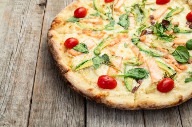 Avokado somon domatesli İtalyan pizzası ve mozzarella fotoğrafçılığı. Kırsal arkaplanda üst görünüm