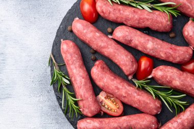 Biberiyeli çiğ et sosisi ve domates fotoğrafçılığı. Kırsal arkaplanda üst görünüm