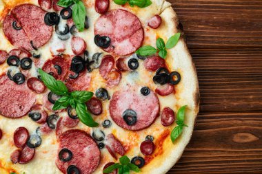 Mozzarella peynirli pizza, salam sosisi, zeytin ve fesleğen. Üst manzara peperonisi