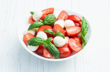 Fesleğen yaprakları, kiraz domatesleri ve mozzarella peyniri. Kase yemek fotoğrafçılığında. Üst görünüm