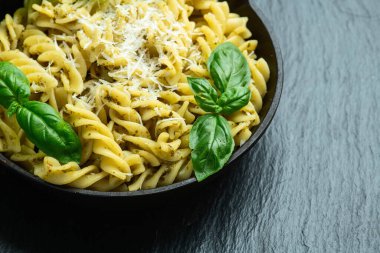 Fesleğen soslu makarna. İtalyan yemek fotoğrafçılığı. Kırsal arkaplanda üst görünüm