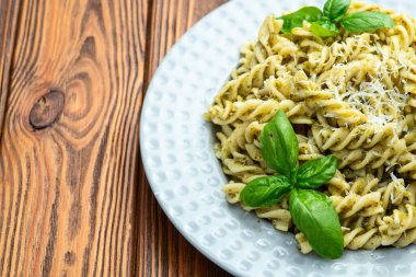 Fesleğen soslu makarna. İtalyan yemek fotoğrafçılığı. Kırsal arkaplanda üst görünüm