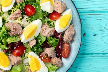 Yumurta ve domates fotoğraflı konserve ton balığı salatası. Kırsal arkaplanda üst görünüm