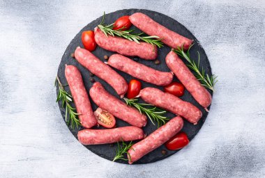 Biberiyeli çiğ et sosisi ve domates fotoğrafçılığı. Kırsal arkaplanda üst görünüm